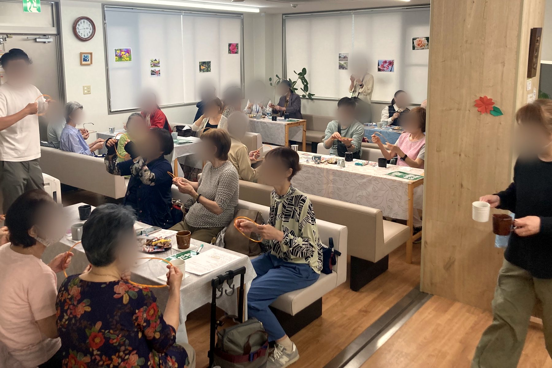 かけはしカフェの会場で、輪を使った体操を楽しむ参加者の皆さん